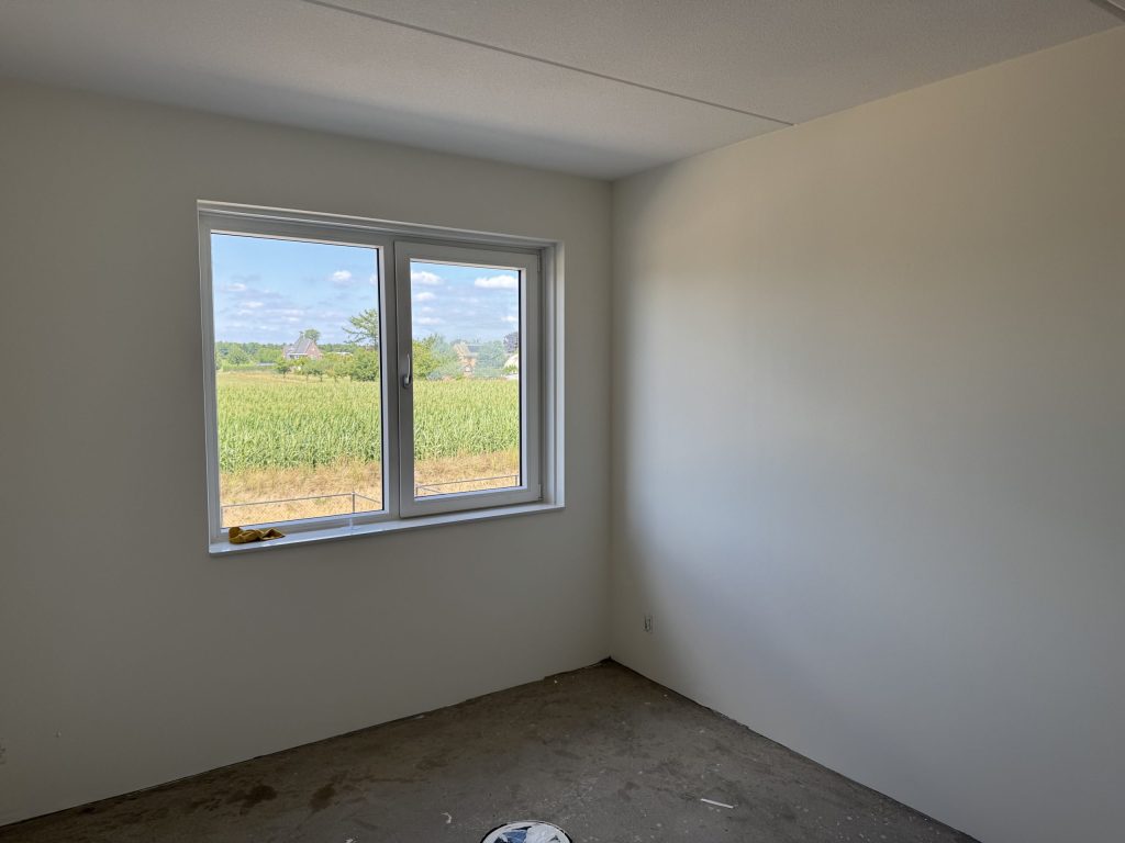 Lege kamer met gladde, lichte wanden en een raam, klaar na het sauzen